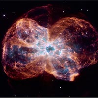 This image, taken by NASA's Hubble Space Telescope, shows the colorful 'last hurrah' of a star like our Sun. The star is ending its life by casting off its outer layers of gas, which formed a cocoon around the star's remaining core. Ultraviolet light from the dying star makes the material glow. The burned-out star, called a white dwarf, is the white dot in the center. Our Sun will eventually burn out and shroud itself with stellar debris, but not for another 5 billion years.<br /><br />Our Milky Way Galaxy is littered with these stellar relics, called planetary nebulae. The objects have nothing to do with planets. Eighteenth- and nineteenth-century astronomers named them planetary nebulae because through small telescopes they resembled the disks of the distant planets Uranus and Neptune. The planetary nebula in this image is called NGC 2440. The white dwarf at the center of NGC 2440 is one of the hottest known, with a surface temperature of nearly 400,000 degrees Fahrenheit (200,000 degrees Celsius). The nebula's chaotic structure suggests that the star shed its mass episodically. During each outburst, the star expelled material in a different direction. This can be seen in the two bow tie-shaped lobes. The nebula also is rich in clouds of dust, some of which form long, dark streaks pointing away from the star. NGC 2440 lies about 4,000 light-years from Earth in the direction of the constellation Puppis.<br /><br />The image was taken Feb. 6, 2007 with Hubble's Wide Field Planetary Camera 2. The colors correspond to material expelled by the star. Blue corresponds to helium; blue-green to oxygen; and red to nitrogen and hydrogen.<br /><br />Image Credit: NASA/JPL/STScI/AURA