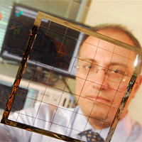 <p>
	Georgia Tech School of Electrical and Computer Engineering professor Manos Tentzeris displays an inkjet-printed rectifying antenna used to convert microwave energy to DC power. This grid was printed on flexible Kapton material and is expected to operate with frequencies as high as 10 gigahertz when complete.</p>
<p>
	Credit: Gary Meek</p>
