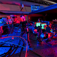 <p>
	A Fermilab scientist works on the laser beams at the heart of the Holometer experiment. The Holometer will use twin laser interferometers to test whether the universe is a 2-D hologram. Credit: Fermilab</p>
