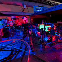 <p>
	A Fermilab scientist works on the laser beams at the heart of the Holometer experiment. The Holometer will use twin laser interferometers to test whether the universe is a 2-D hologram. Credit: Fermilab</p>
