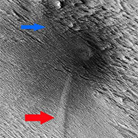 <p>
	HiRISE image of the study area showing the central crater with two dagger-like features extending at an angle (red and blue arrows). Called scimitars, these features most likely resulted from shockwave interference just before impact.</p>
<p>
	Image: NASA/JPL-Caltech/The University of Arizona</p>
