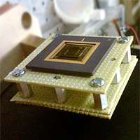 <p>
	A new energy harvesting device converts low-frequency vibrations into electricity. The device, the size of a U.S. quarter, is shown mounted on a stand.<br />
	Photo: Arman Hajati</p>
