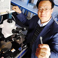 Zhong Lin Wang, Regents Professor in the School of Materials Science and Engineering at Georgia Tech, holds a prototype DC nanogenerator fabricated using an array of zinc oxide nanowires.<br /><br />Georgia Tech Photo: Gary Meek