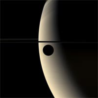The moon Rhea glides silently onto the featureless, golden face of Saturn in this mesmerizing color movie. Image credit: NASA/JPL/Space Science Institute