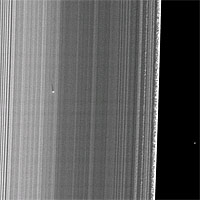 <p>
	The Cassini spacecraft captured this image of a small object in the outer portion of Saturn's B ring casting a shadow on the rings as Saturn approached its August 2009 equinox.</p>
<p>
	The new object, situated about 650 kilometers (400 miles) inward from the outer edge of the B ring, was found by the presence of a localized bright feature and the detection of its shadow, which stretches 36 kilometers (22 miles) across the rings. Cassini scientists suspect the object is a solid moonlet, as opposed to a diffuse debris cloud, as might result from an impact, because no shadows have been observed accompanying any known impact plumes observed by Cassini. The shadow's length implies that the moonlet is protruding about 150 meters (500 feet) above the ring plane. If the moonlet is orbiting in the same plane as the ring material surrounding it, which is likely, it must be about 300 meters (1,000 feet) from bottom to top. However, the width of the bright feature implies that the moonlet must be several times wider than that height.</p>
<p>
	Unlike the band of moonlets discovered in Saturn's A ring earlier by Cassini (see PIA07792 and PIA07790), this object is not attended by a long propeller feature. However, the relatively large width of the bright features relative to the height implied by the long shadow may indicate that a fairly localized, perhaps truncated propeller feature surrounds a roughly spherical body that is not directly imaged. The A ring moonlets, which also have not been directly imaged, were found because of the propeller-like narrow gaps on either side of them that they create as they orbit within the rings. The lack of an extended propeller feature surrounding the new moonlet may not be not surprising because the B ring is dense, and the ring material in a dense ring would be expected to fill in any gaps around the moonlet more quickly than in a less dense region like the mid-A ring. Alternatively, it may simply be harder in the first place for a moonlet to create propeller-like gaps in a dense ring.</p>
<p>
	Straw-like patterns of clumping ring material are also visible along the edge of the outer B ring near the right of this image. See PIA09855 to learn more about these features.</p>
<p>
	This image and others like it (see PIA11656 and PIA11659) are only possible around the time of Saturn's equinox which occurs every half-Saturn-year (equivalent to about 15 Earth years). The illumination geometry that accompanies equinox lowers the sun's angle to the ring plane and causes out-of-plane structures to cast long shadows across the rings.</p>
<p>
	This view looks toward the sunlit side of the rings from about 42 degrees below the ring plane. Background stars are visible on the right of the image. They appear elongated by the camera's exposure time.</p>
<p>
	The image was taken in visible light with the Cassini spacecraft narrow-angle camera on July 26, 2009. The view was obtained at a distance of approximately 296,000 kilometers (184,000 miles) from Saturn and at a Sun-Saturn-spacecraft, or phase, angle of 120 degrees. Image scale is about 1 kilometer (4,680 feet) per pixel.</p>
