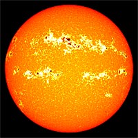 In this image from an active solar period in March 2001, colors are shifted to highlight the contrast between sunspots (black and dark red) and the faculae that surround them (bright yellow). During the peak of the 11-year solar cycle, the expansion of faculae outweighs the darkening from increased sunspot activity. The result is a net increase in solar brightness. <br /><br />(Image courtesy NASA.)