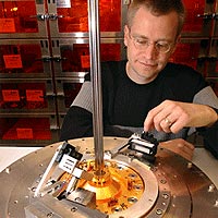 Sandia National Laboratories researcher Daniel Sinars demonstrates the setup he and his team created to peer into the center of Sandia’s Z machine at the moment of firing. The crystal under his finger is attached to portions of a Z target configuration. (Photo by Randy Montoya) 